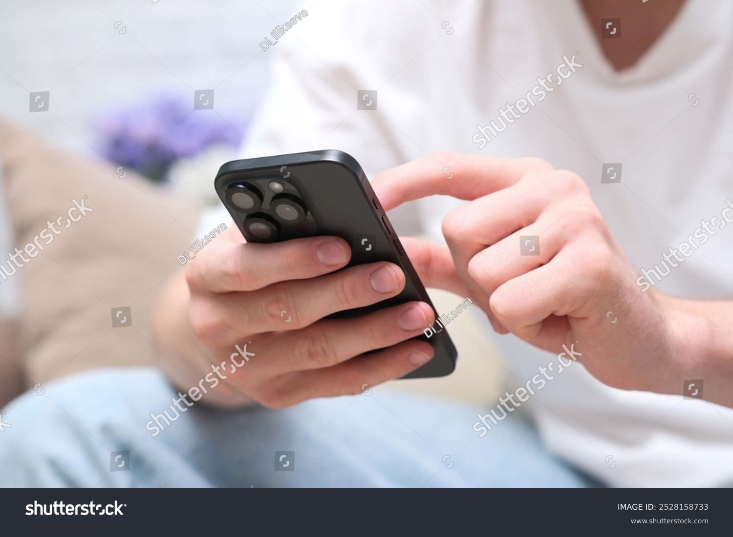 A picture of someone holding an Apple iPhone, with the ShutterStock watermark overlaid..